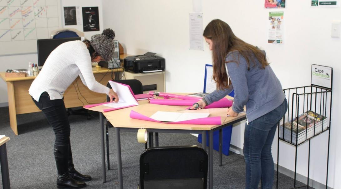 Two Journalism interns prepare materials for a workshop in Cape Town, South Africa. Students doing Journalism internships in South Africa create materials for a creative workshop.